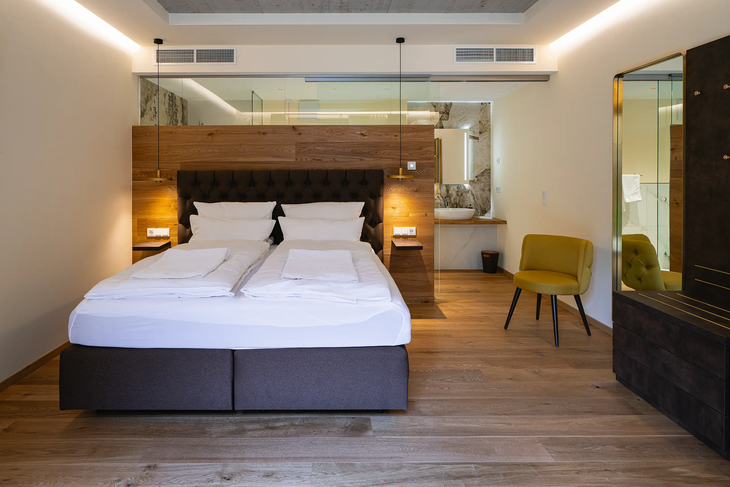 Superior-Zimmer 22 im Neubau mit Doppelbett, gelbem Sessel und Holzboden