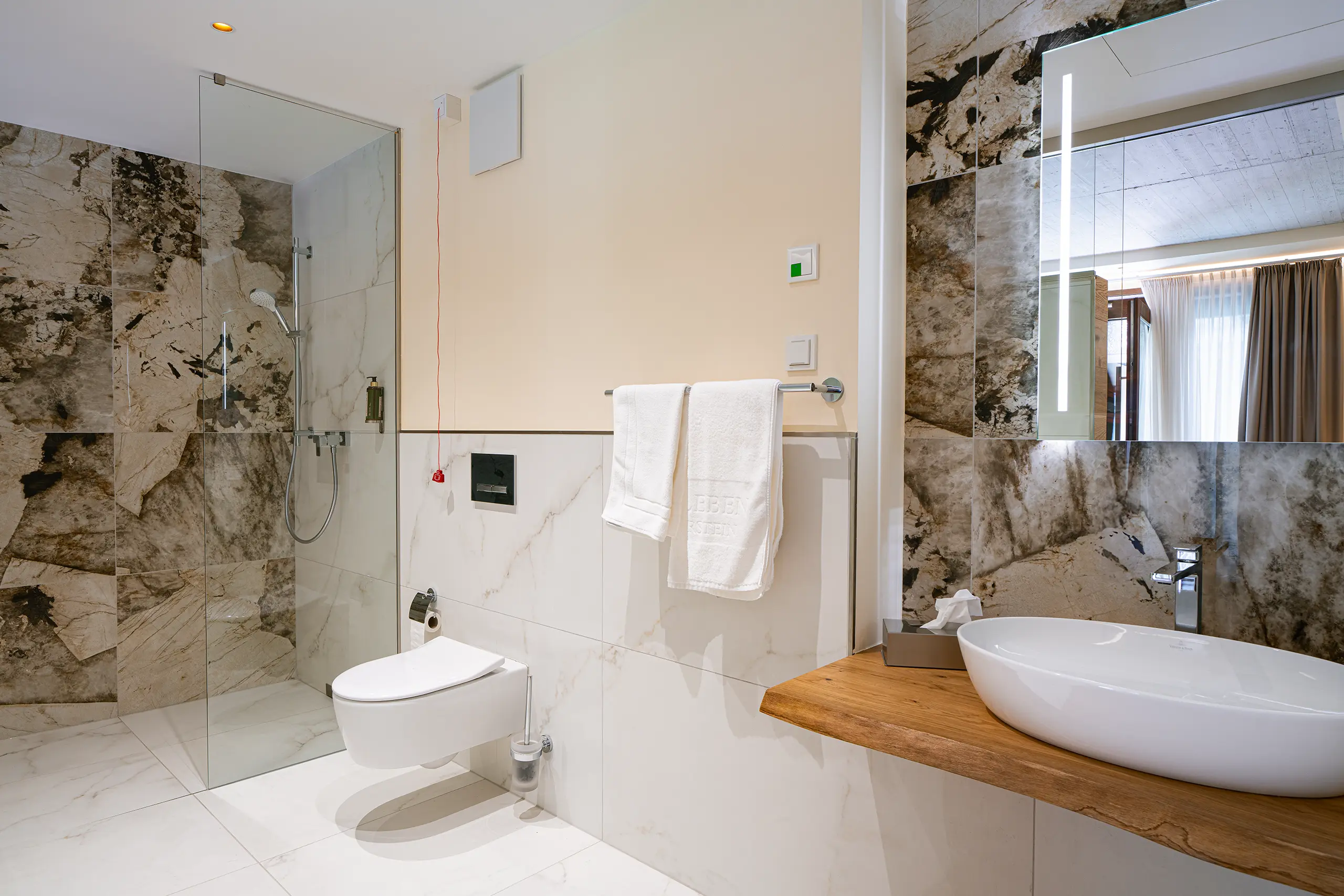 Badezimmer in Zimmer 22 im Neubau mit Marmorfliesen, Badewanne und Dusche