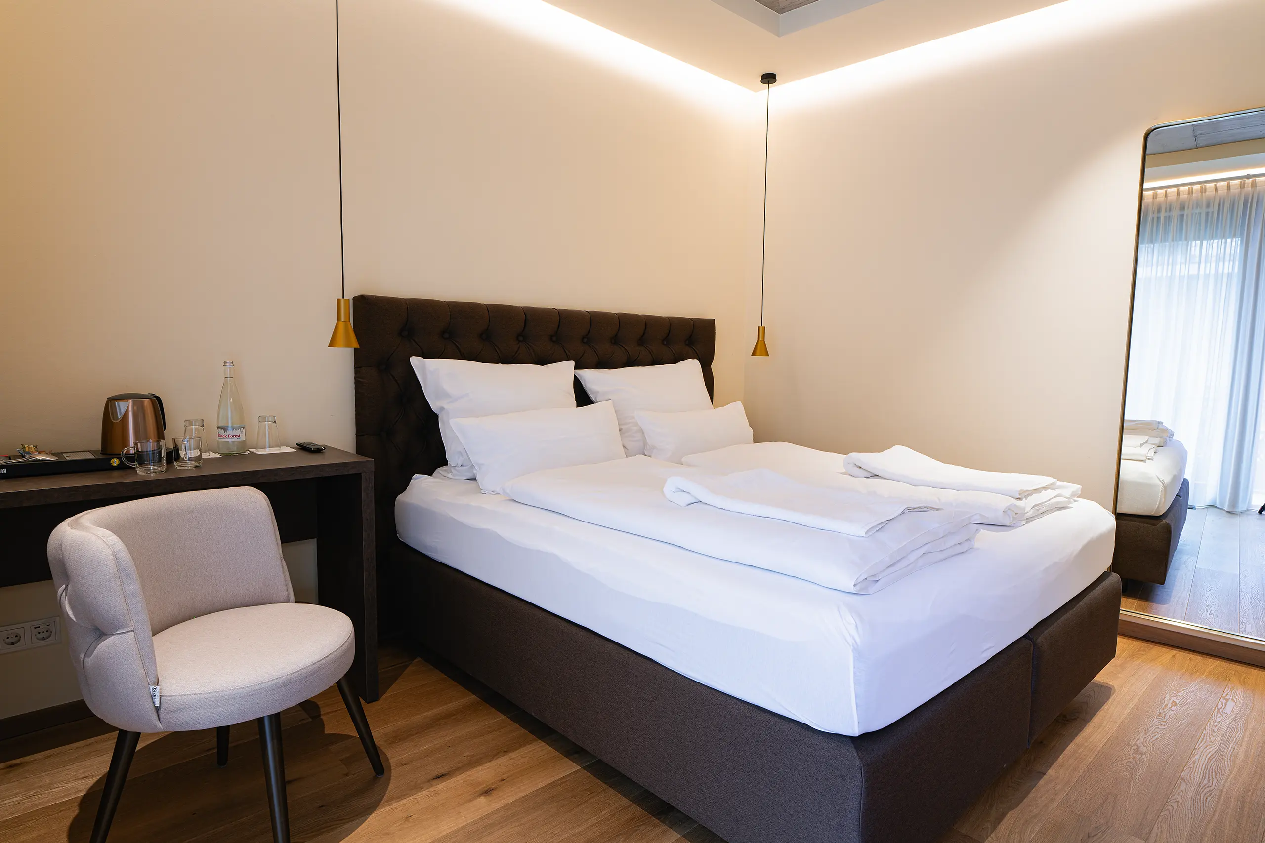 Superior-Zimmer 23 im Neubau mit Doppelbett und rosafarbenem Sessel