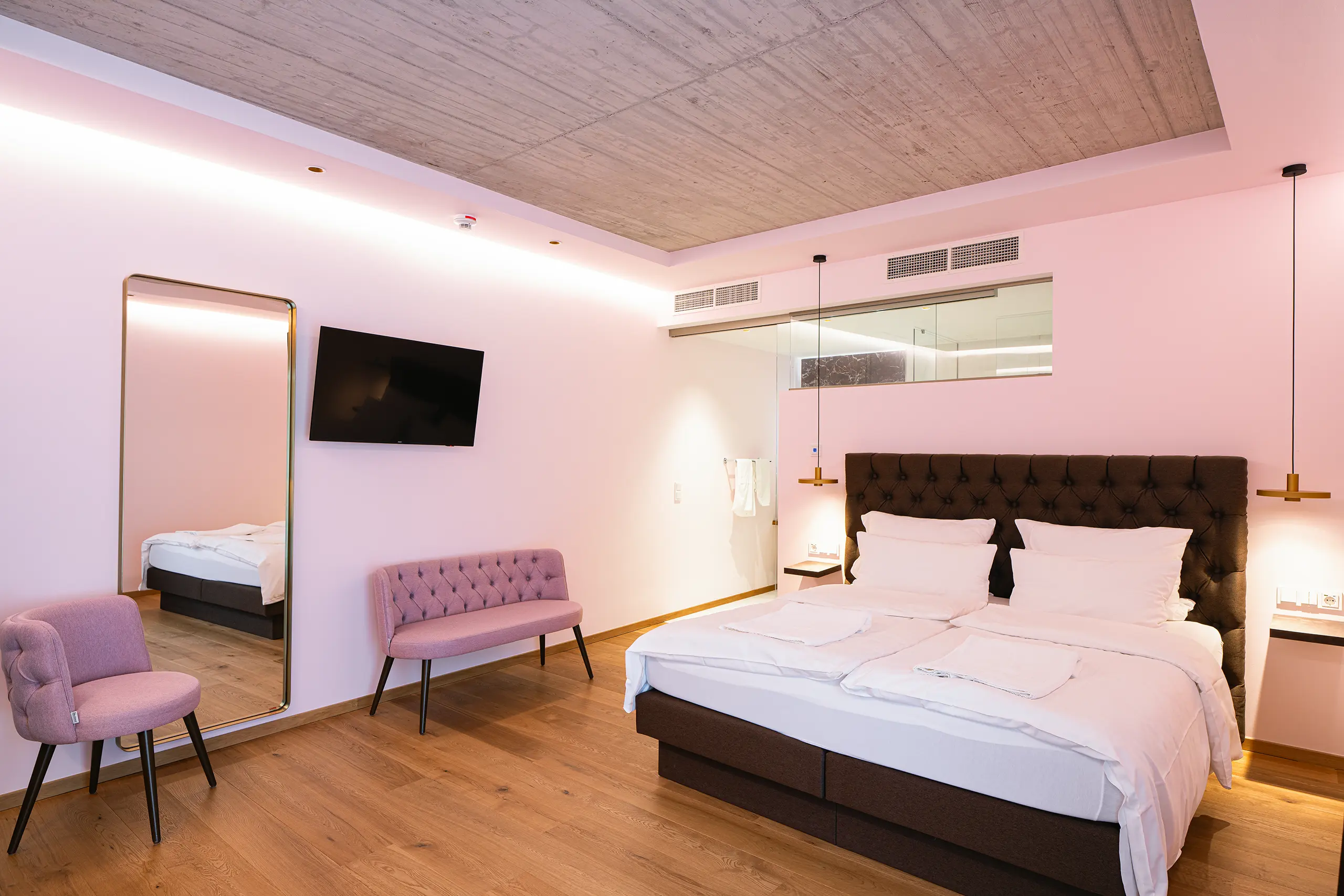 Superior-Zimmer 24 im Neubau mit Doppelbett und rosafarbenen Sesseln