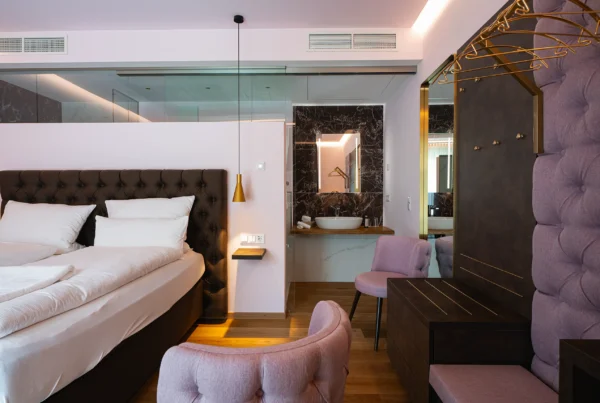 Superior-Zimmer im Neubau mit Doppelbett, Sessel und indirekter Beleuchtung