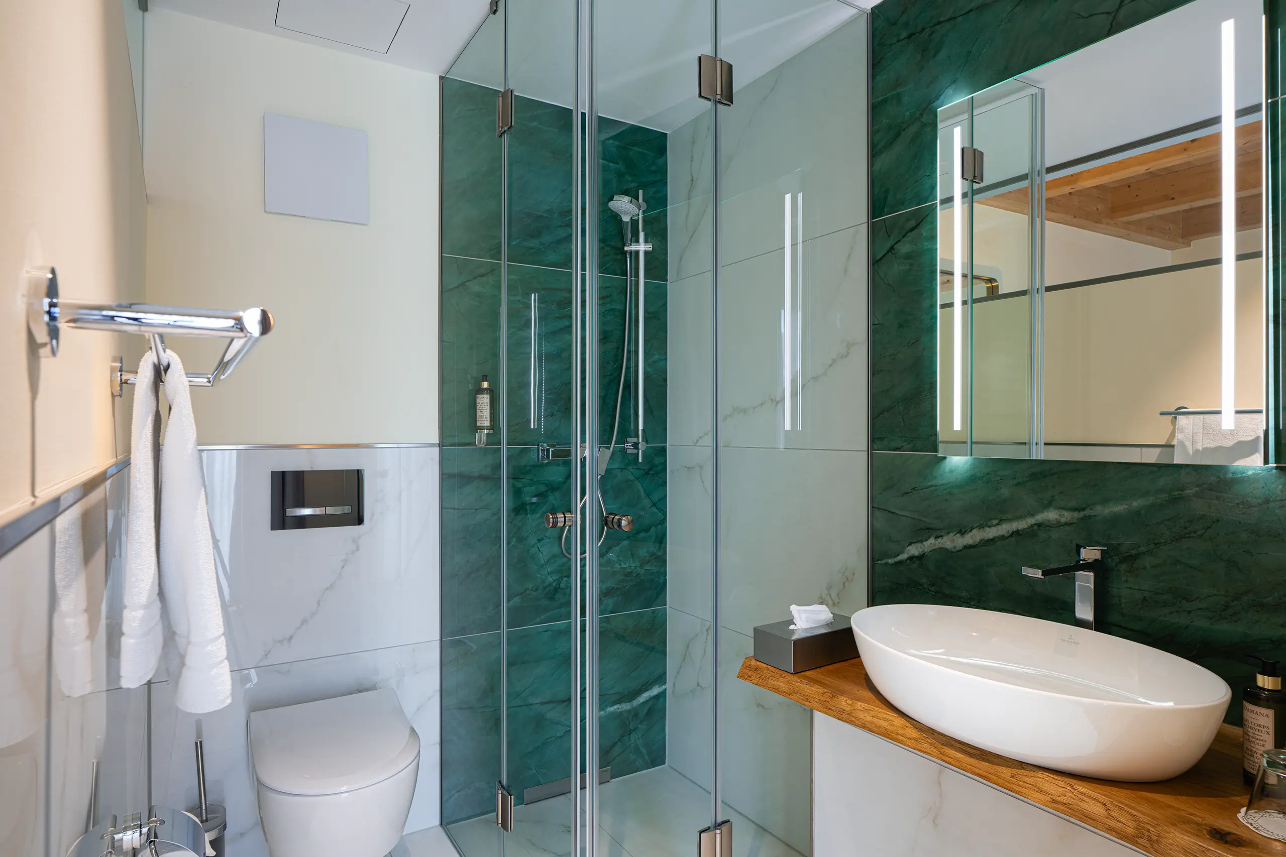 Badezimmer in Zimmer 27 im Neubau mit grüner Marmordusche und Waschbecken