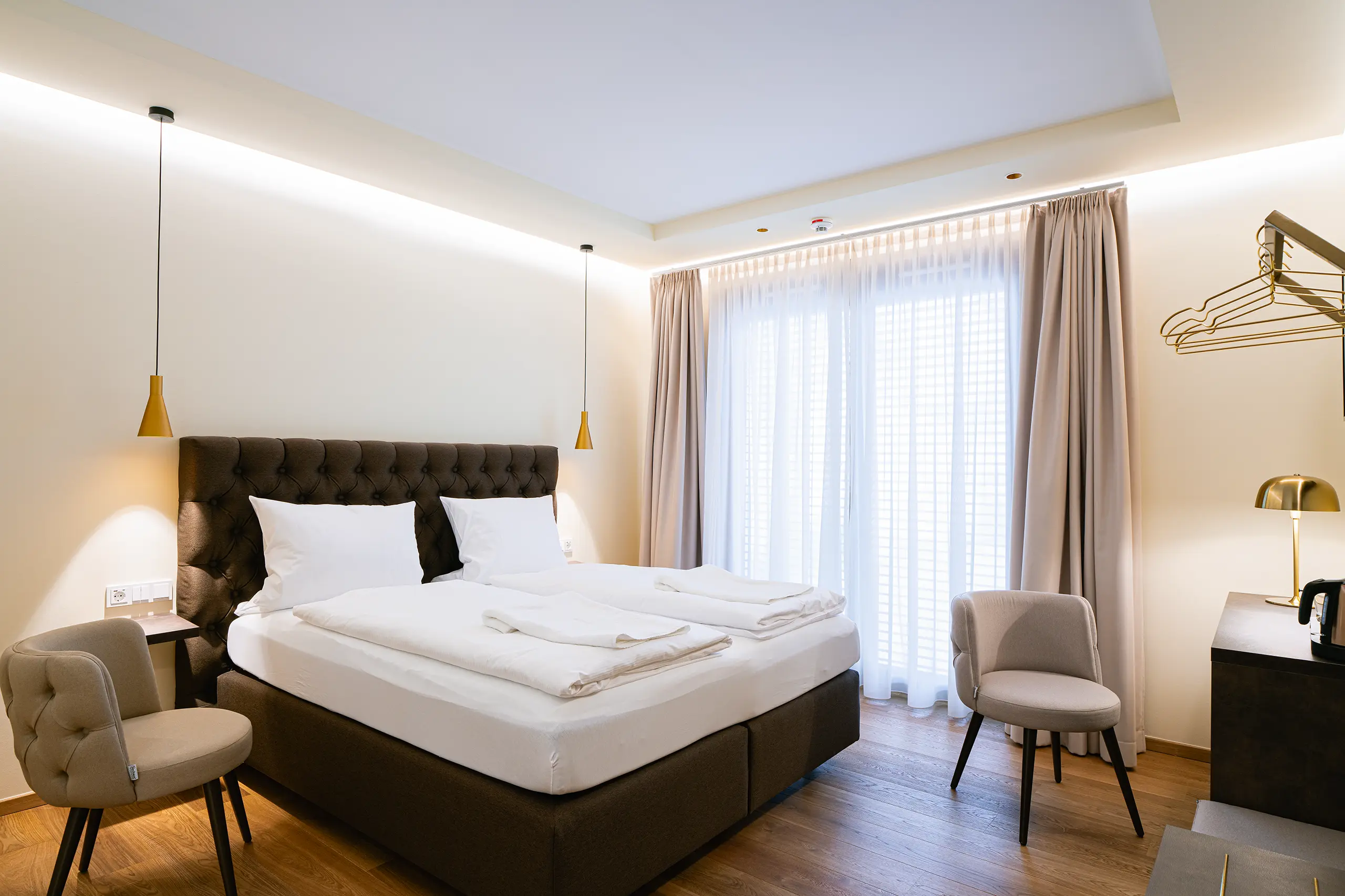 Superior-Zimmer 31 im Neubau mit Doppelbett, Sessel und Vorhängen