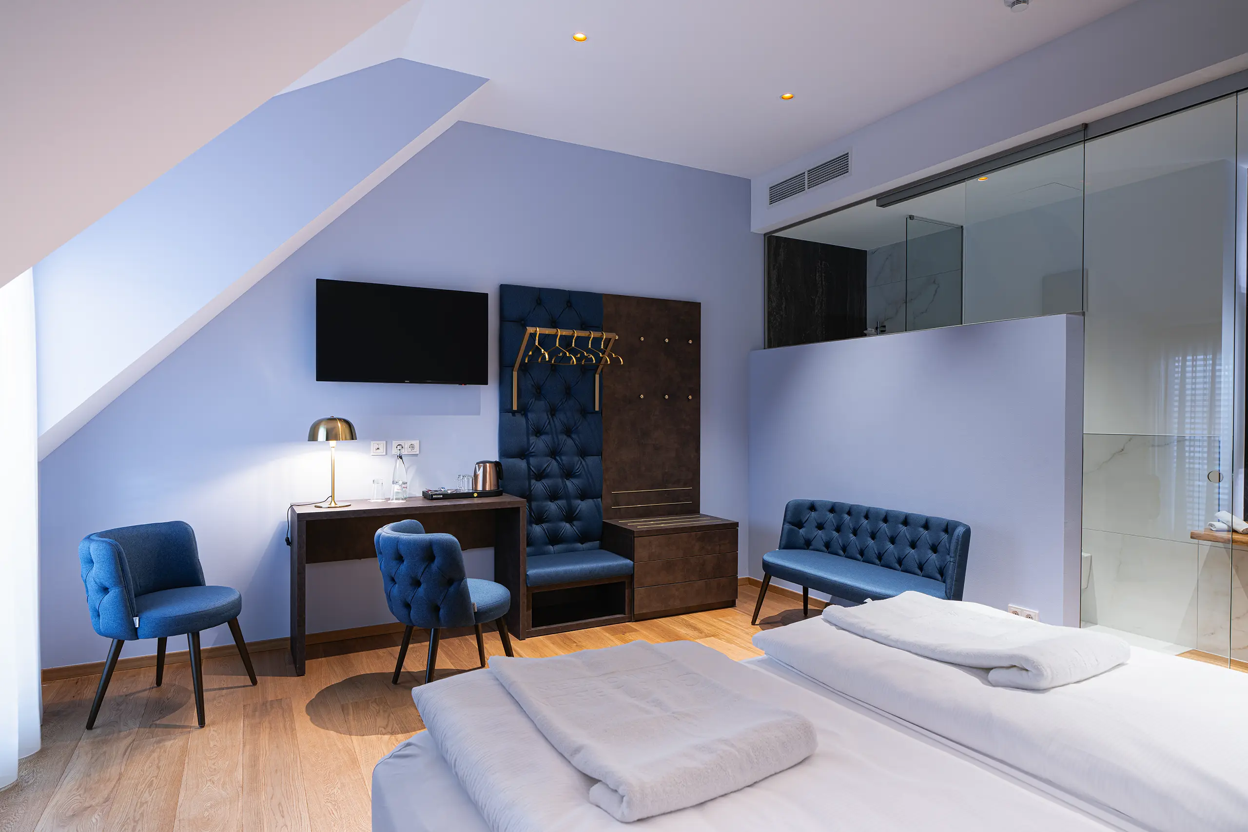 Superior-Zimmer 40 im Neubau mit Doppelbett, blauer Sitzbank und Schreibtisch unter der Dachschräge
