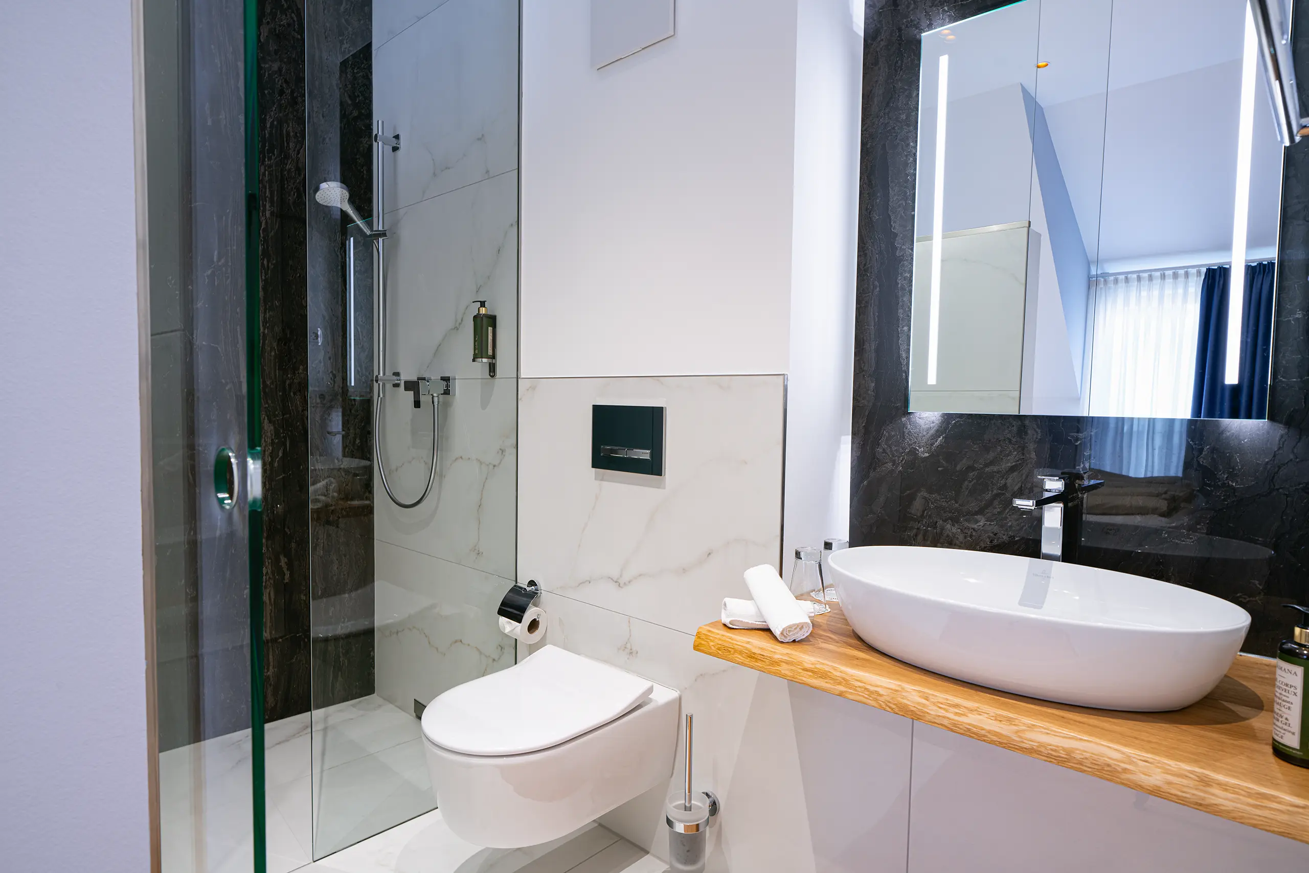 Badezimmer in Zimmer 43 im Neubau mit Waschbecken, WC und Glasdusche