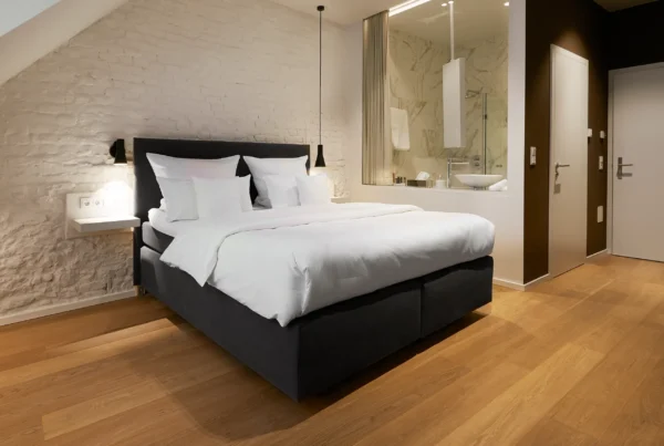 Superior-Zimmer in der Scheune mit Doppelbett, Natursteinwand und Blick ins Bad