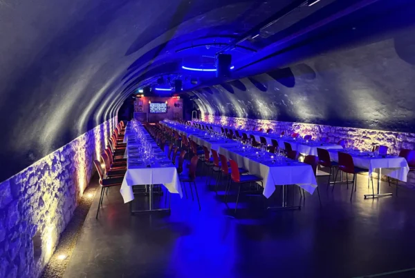 Gedeckte Tische im blau beleuchteten Gewölbekeller für ein Event-Dinner