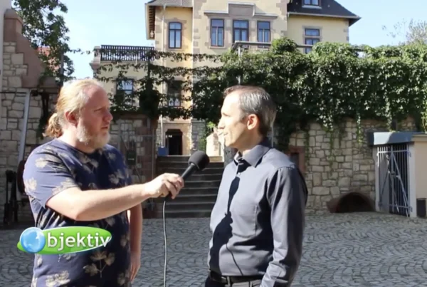Reporter interviewt Gastgeber im Innenhof vor dem Schlösschen, Vorschaubild zum Fernsehbeitrag